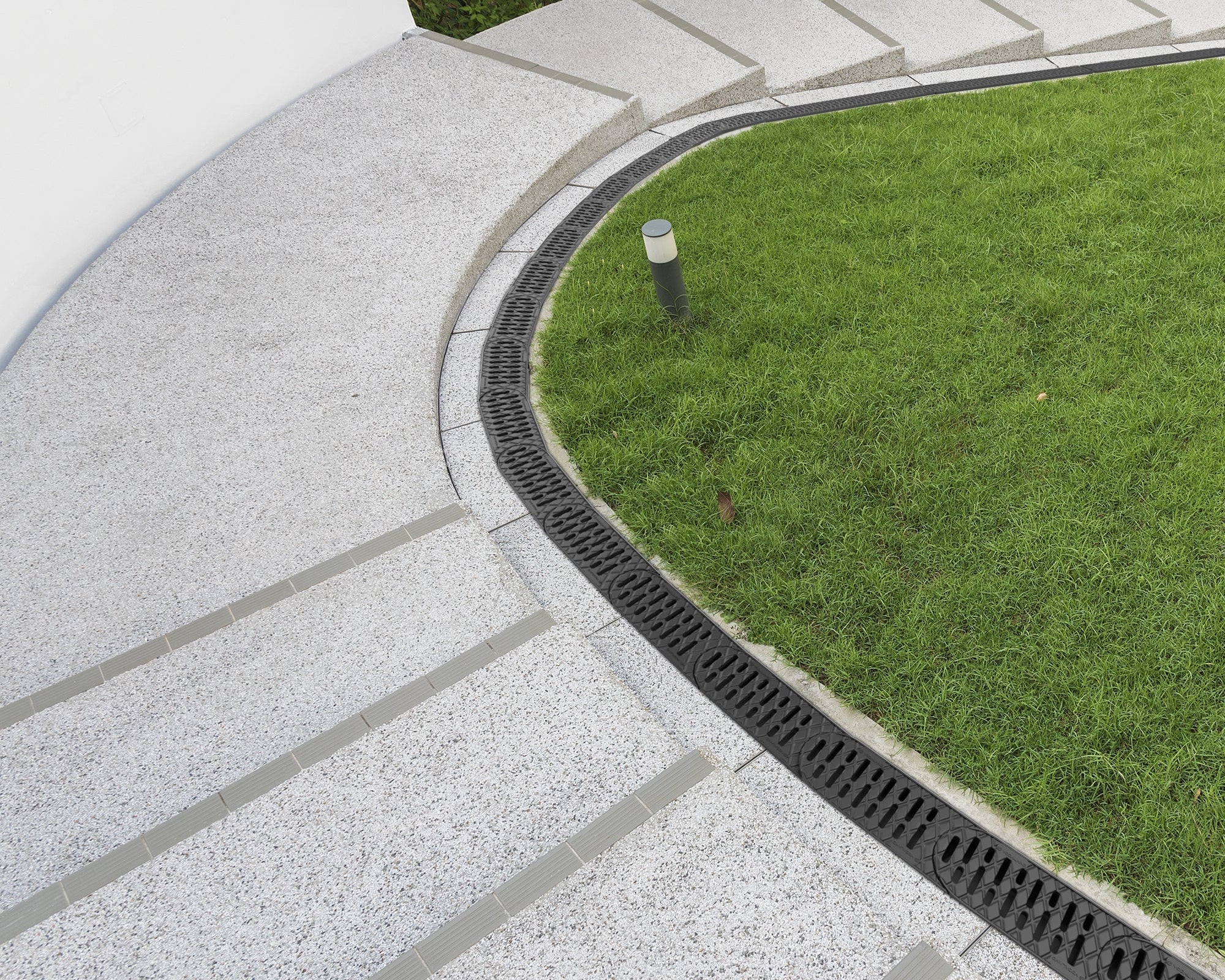 Concrete pathway with grass border and drain cover